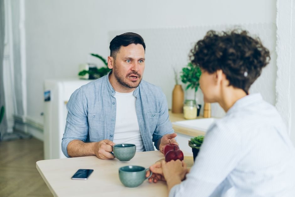 Pareja conversando en la mesa de la cocina sobre salud sexual y las vías de contagio de la sífilis