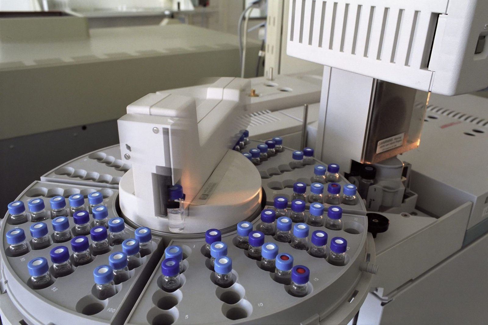 Analizador automático de laboratorio con viales de muestra dispuestos en un carrusel, sin personas