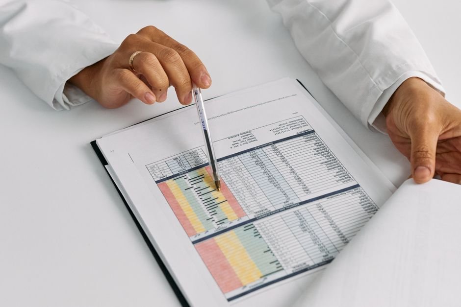 Primer plano de manos señalando un expediente clínico sobre un escritorio, sin mostrar el rostro