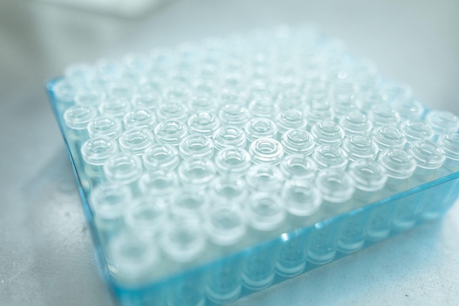 Charola con viales de vidrio transparentes en un laboratorio, sin personas